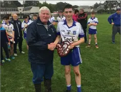  ??  ?? Aughrim’s Sam Carroll is presented with the Plate by Mick Hagan.