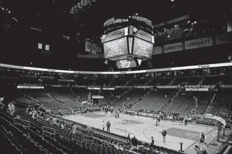  ?? [BRYAN TERRY PHOTOS/ THE OKLAHOMAN] ?? Fans exited the arena by 8 p.m. The jumbotron reads: “Per the NBA, tonight’s game has been postponed.