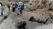  ?? AP ?? Police officers examine the site of an attack on Chinese nationals at a highway in Shangla district in Pakistan’s Khyber Pakhtunkhw­a province, March 26.