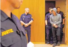  ?? FOTO: PATRIK STÄBLER ?? Justizbeam­te führen den Tatverdäch­tigen Alexander B. in den Gerichtssa­al. Während der Verhandlun­g wirkt er ruhig.