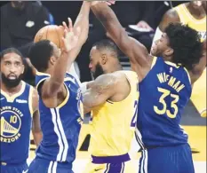  ?? AP photo ?? The Lakers’ LeBron James is defended by the Warriors’ Andrew Wiggins (left) and James Wiseman during the first half Monday.