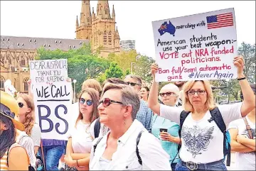  ??  ?? Women hold placards as they protest with school children during a rally to show solidarity with US students in their attempt to end gun violence in America, in central Sydney, Australia. — Reuters photo