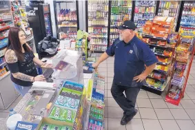  ?? GREG SORBER/JOURNAL ?? Ron Schorr talks with his daughter as she works the counter of their Paradise Hills Chevron station. Schorr said he no longer feels comfortabl­e letting his family work in the evening — and now closes the station two hours earlier — due to a recent...