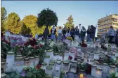  ?? TERJE BENDIKSBY — NTB ?? Young people on Friday look at the floral tributes and candles left for the victims of a bow-and-arrow attack on Stortorvet in Kongsberg, Norway.