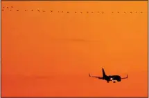  ?? ?? A passenger jet approaches Kansas City Internatio­nal Airport to land as geese fly overhead, Friday, Dec. 30, 2022, in Kansas City, Mo. Hush trips are an increasing­ly popular travel trend where remote employees work from a vacation destinatio­n and don’t disclose their location to their employer. (AP)