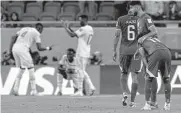  ?? Hassan Ammar / Associated Press ?? Senegal players in background celebrate their victory as Qatar players show their disappoint­ment.