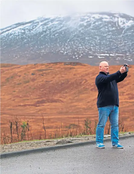 ?? Picture Steve Cox ?? A tourist takes a selfie with a red deer in a carpark near Glencoe