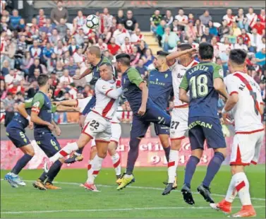  ??  ?? COMPETIDO. El delantero rayista De Tomás pelea por un balón aéreo durante el partido.