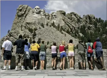  ??  ?? In this July 21, 2005 file photo, visitors watch while workers pressure wash the granite faces of George Washington (left), Thomas Jefferson, Theodore Roosevelt and Abraham Lincoln at Mount Rushmore National Memorial in South Dakota. AP PHOTO/CHARLIE...