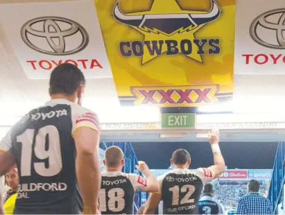  ?? Picture: COWBOYS MEDIA ?? IT’S TRADITION: Our back-row star Jason Taumalolo reaches up to touch the sign on his way out for a game at 1300SMILES Stadium in 2014. 'You are now entering Cowboys Country'