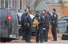  ?? ANGELA PETERSON / MILWAUKEE JOURNAL SENTINEL ?? Milwaukee police officers and other investigat­ors gather on Milwaukee’s northwest side where the body of a possible suspect in an incident at the Roundy’s warehouse was found.