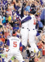  ?? LYNNE SLADKY/ASSOCIATED PRESS ?? Adam Jones, left, celebrates with his United States’ teammate Nolan Arenado (12) after hitting the gamewinnin­g RBI single against Colombia.