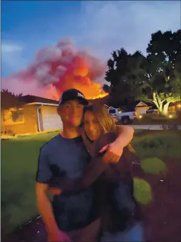  ?? COURTESY OF CHERYL DUFFUS ?? Cheryl Duffus of Salinas hugs her 18-year-old son, Tyler, as he heads off to his first year of college in San Luis Obispo as the River Fire burns in the hills behind her house.