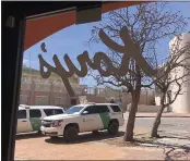  ??  ?? Two Border Patrol trucks are parked outside a clothing store located steps away from the U.S.-Mexico border on in Nogales, Ariz.