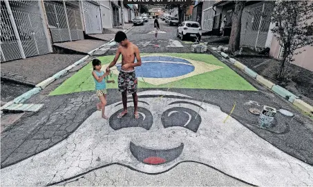  ?? | EPA ?? PEOPLE paint a street in Sao Paulo, Brazil, in celebratio­n of the Fifa World Cup, which kicks off in Qatar on Sunday.