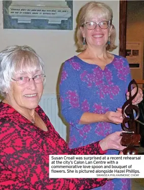  ?? SWANSEA PHILHARMON­IC CHOIR ?? Susan Croall was surprised at a recent rehearsal at the city’s Calon Lan Centre with a commemorat­ive love spoon and bouquet of flowers. She is pictured alongside Hazel Phillips.