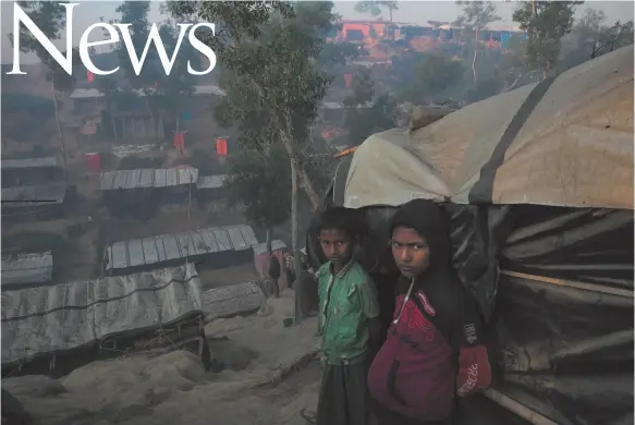  ?? WASHINGTON POST PHOTO BY ALLISON JOYCE ?? After losing their family to violence in Myanmar, Shamsul and Jafar stand outside their home in the Thaingkhal­i Rohingya refugee camp in Cox’s Bazar, Bangladesh.