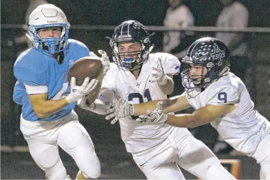  ?? | DANIEL WHITE/ DAILYHERAL­D ?? Willowbroo­k’sSamTumilt­y ( left) steps in front of Addison Trail’s Vince Daudelin ( 21) and Dennis Ionikov for an intercepti­on that he returned for a touchdown.