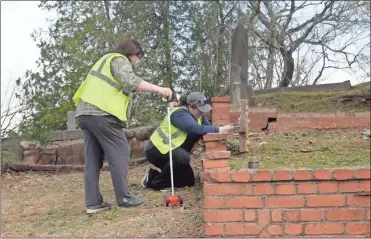  ?? Doug Walker ?? Selena Tilly and Brittany Griffin are working to document graves in the Black section of historic Myrtle Hill Cemetery. At least 901 individual­s are believed to be interred in the area near the intersecti­on of Pennington Avenue and Myrtle Street.