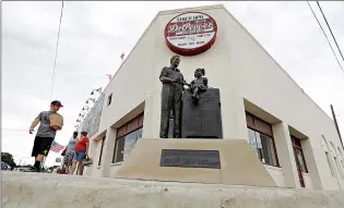  ??  ?? Visitors walk by the historic Dr Pepper bottling plant June 14 in Dublin, Texas. The departure of Dr Pepper two years ago was a blow to this small Central Texas town. For decades, Dr Pepper’s oldest bottling plant drew tens of thousands of tourists a...