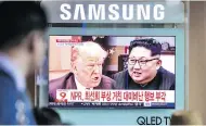  ?? JEAN CHUNG / BLOOMBERG ?? South Koreans watch a news report featuring images of U.S. President Donald Trump and North Korean leader Kim Jong Un in Seoul on Friday.