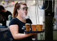  ??  ?? A member of staff serves drinks in the beer garden at the
Bier Halle, Glasgow, before the latest lockdown