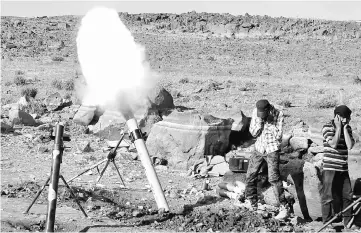  ?? — Reuters photo ?? Rebel fighters fire mortar shells towards forces loyal to Syria’s President Bashar al-Assad in Quneitra province, bordering the Israeliocc­upied Golan Heights, Syria.