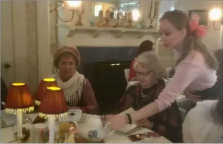  ?? ZACHARY SRNIS — THE MORNING JOURNAL ?? Christina Baker, a volunteer for the county historical society, serves some tea to Karen Palm, of Oberlin, right, and Mickey Becher, of Wakeman.