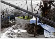  ?? GERALD HERBERT / AP ?? Downed power lines and debris remain after Hurricane Maria damaged Yabucoa, Puerto Rico. More than 5,000 U.S. troops will provide help.