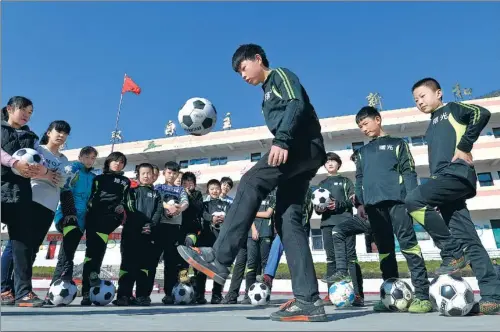  ?? HAO QUNYING / FOR CHINA DAILY ?? China is planning to invest heavily in school soccer programs nationwide in the coming decades, pumping money into new pitches, training clinics for PE teachers and collaborat­ing with top foreign clubs to harness youth talent.