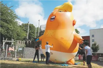  ?? Isabel Infantes, AFP ?? Activists inflate their Trump baby balloon Tuesday in London. Organizers are hoping to stage one of England’s biggest demonstrat­ions in decades to coincide with President Donald Trump’s visit.