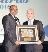  ??  ?? Hospitalit­y Personalit­y of the Year Kevin Hendrickso­n (right) accepts his award from Minister of Tourism Edmund Bartlett.