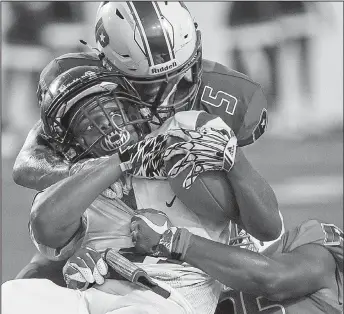  ?? Arkansas Democrat-Gazette/MITCHELL PE MASILUN ?? Little Rock Parkview’s Zach Smith (5) and Trevon Hadley tackle Mills running back Corbin Humphrey (middle) during the Patriots’ 67-26 victory over the Comets on Thursday at War Memorial Stadium in Little Rock.