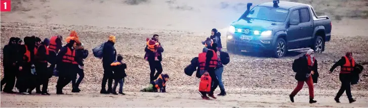  ?? ?? Beginning their desperate journey: Just after dawn yesterday a group of 40 migrants, including six children, walk on to the beach at Wimereux, north of Boulogne