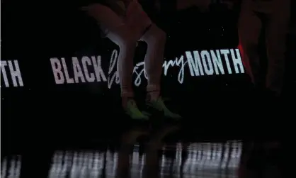  ??  ?? ‘Members of the Toronto Raptors sit on a sign honoring Black History Month before a game.’ Photograph: Mary Holt/USA Today Sports