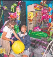  ??  ?? Abigail and food manager Clay Stark prepare balloons for decoration ahead of the park opening.