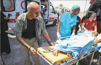  ?? Abdirazak Hussein Farah / AFP / Getty Images ?? A woman wounded in the Mogadishu bombing is transporte­d to a Turkish military aircraft for medical evacuation to Turkey. The plane also delivered critical medical supplies to Somalia.