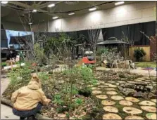  ??  ?? A worker touches up one of the elaborate horticultu­ral displays visitors can expect to see this weekend at the annual Capital District Garden & Flower Show in the McDonough Sports Complex at Hudson Valley Community College.