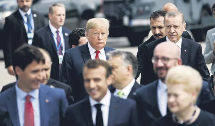  ??  ?? President Recep Tayyip Erdoğan (R) and U.S. President Donald Trump (L) follow other leaders for a photo shoot during the NATO summit in Brussels, July 11.
