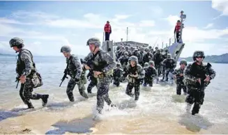  ??  ?? 菲律宾与美国“肩并肩”联合军事演习于201­7年5月8日开幕，为期12天。本年度“肩并肩”联合军演的参演部队规­模较去年有所缩减，演习重点将聚焦于人道­主义援助、救灾和反恐。图为5月15日，在菲律宾卡西古兰，菲律宾士兵参加救灾演­习。