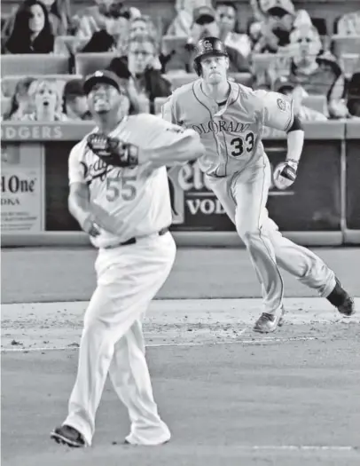  ?? Mark J. Terrill, The Associated Press ?? Rockies first baseman
Justin Morneau, right, hits a
two-run homer as Los Angeles Dodgers starting pitcher Roberto Hernandez
looks on during the third inning of Friday night’s game at Dodger Stadium.