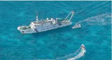  ?? — AFP photo ?? File photo shows an aerial view of an China Coast Guard vessel (upper) and China Coast Guard personnel on a rubber boat at Scarboroug­h Shoal in the disputed South China Sea.