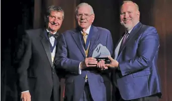  ?? ?? Phil Winslow, Colorado Springs automobile dealer, was inducted into the Colorado Automotive Hall of Fame last May. Presenting the award are Todd Maul, left, and Brent Wood, right. (CADA)