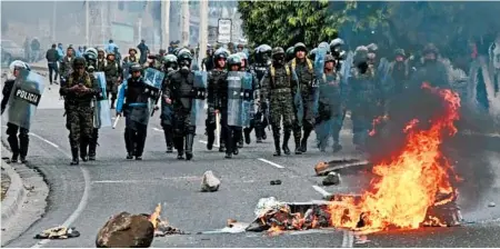  ?? ORLANDO SIERRA/GETTY-AFP ?? Honduran army soldiers and police officers in riot gear clash Friday with supporters of opposition presidenti­al candidate Salvador Nasralla.