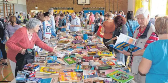  ?? FOTO: KERSTIN SCHWIER ?? Bücher gehen immer! Einige Besucher decken sich gleich mit Lesestoff für den Sommerurla­ub ein.