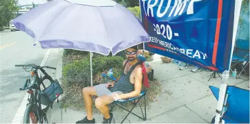  ??  ?? •
Ray Renaud, de Daytona Beach, Florida, se cubre con una sombrilla mientras simpatizan­tes del presidente Donald Trump acamparon ayer frente al Amway Center antes de un evento para dar inicio a la campaña de reelección 2020 en Orlando, Florida.