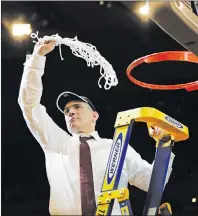  ?? "1 1)050 ?? South Carolina head coach Frank Martin swings the net around after cutting it down after beating Florida 77-70 in the East Regional championsh­ip game of the NCAA men’s college basketball tournament on Sunday in New York.