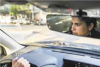  ?? Jessica Christian / The Chronicle ?? Lorena Melgarejo, who monitors Immigratio­n and Customs Enforcemen­t activity, drives through S.F.’s Mission District after getting a tip about a possible ICE van in the neighborho­od.