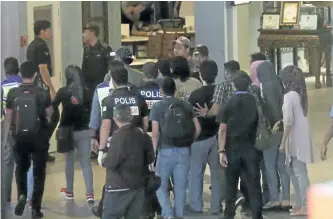  ?? THE ASSOCIATED PRESS ?? Police and other officials walk through a re-enactment of the murder of Kim Jong Nam at Kuala Lumpur Internatio­nal Airport, in Sepang, Malaysia, on Friday.