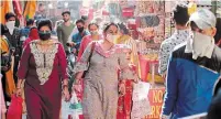  ?? CHANNI ANAND THE ASSOCIATED PRESS ?? People wear masks as they shop at a market ahead of Hindu festivals in Jammu, India, on Thursday.